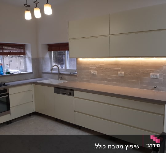 מטבח מודרני עם ארונות בהירים ותאורה תחתונה